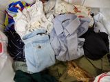 une pile de vêtements posée sur un lit