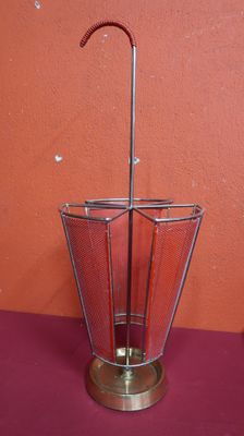 a metal umbrella holder with a metal handle on a table