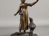 bronze statue of a woman with a dog on a rock
