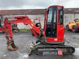 a red excavator that is parked in a parking lot