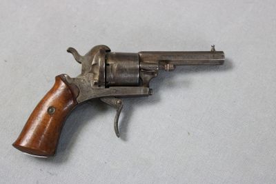 an old revolver with a wooden handle on a white surface