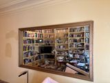 un miroir qui reflète une bibliothèque dans un salon