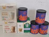 several boxes of coffee are sitting on a table next to a cup of coffee