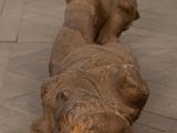 a wooden sculpture of an elephant laying on the floor