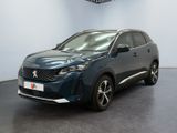 La voiture bleue est garée dans une grande pièce au sol noir.