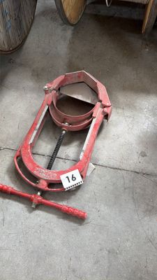 une photo d'une luge rouge posée par terre à côté de tonneaux
