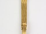 yellow gold plated metal tie bar on a white background