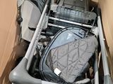 a baby stroller in a cardboard box with luggage in it