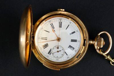 une montre de poche en or avec des chiffres romains