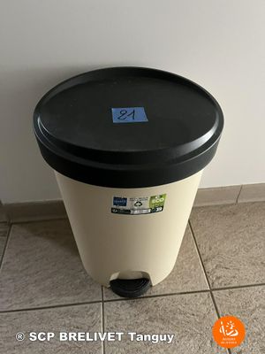 a black and white trash can sitting on a tiled floor