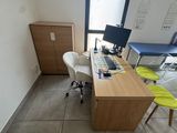 a desk with a computer and a chair in a room