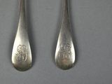 three spoons and a fork on a table with a gray background