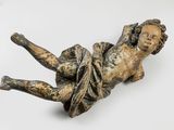 statue of a child laying on its back on a white surface