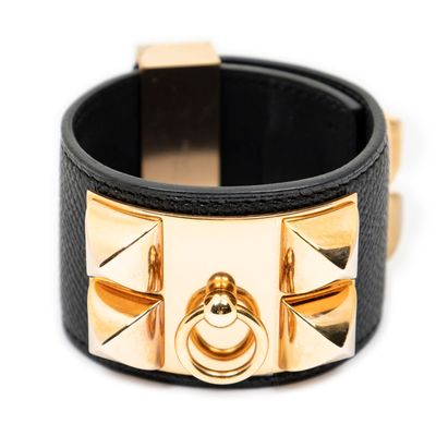 leather cuff bracelet with gold rivets and studs on a white background