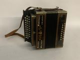 an old accordion sitting on top of a white surface