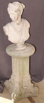 une statue représentant une femme assise sur un socle