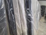 de nombreux matelas emballés dans des sacs en plastique dans un entrepôt