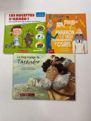 trois livres pour enfants sont posés sur une surface blanche