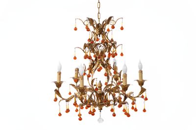 an image of a gold chandelier with red berries hanging from the ceiling
