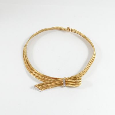 gros plan d'un collier en or sur une surface blanche