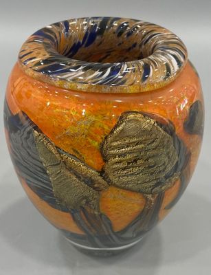 a vase with a bird design on it sitting on a table