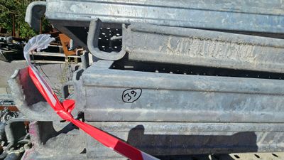une pile de récipients métalliques auxquels est noué un ruban rouge
