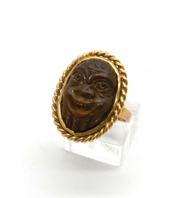 un gros plan d'une bague sur laquelle est représenté un visage