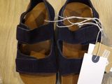 a pair of shoes on the floor with a price tag