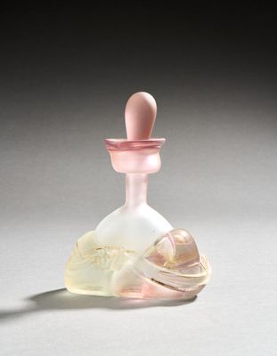 a small glass bottle with a pink top on a white surface