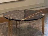 a black and gold coffee table on a marble floor