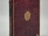 un vieux livre avec un emblème en or sur la couverture