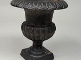 antique cast iron urn on stand on a white background