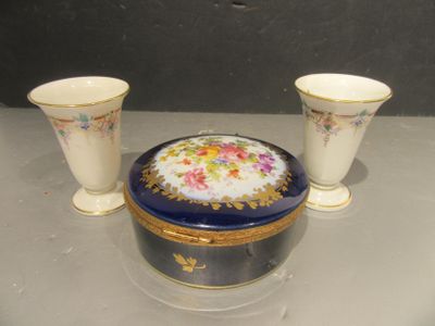 trois vases et une boîte posés sur une table