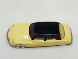 a yellow toy car that is sitting on a white surface