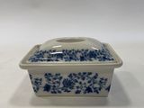 a small blue and white dish on a white table