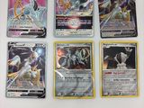quatre cartes Pokémon différentes posées sur une surface blanche