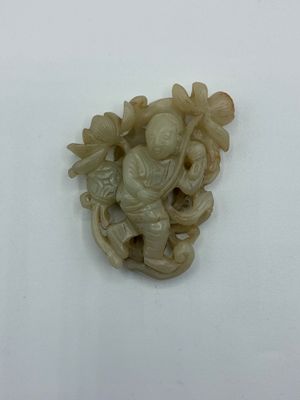 figurine en ivoire sculpté représentant un homme avec un oiseau perché sur une branche