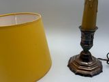 une lampe et un bougeoir posés sur une table