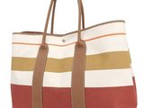 a large striped tote bag sitting on top of a white surface