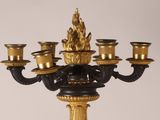 a gold and black candelier with five candles on it
