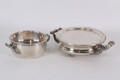 deux plats plaqués argent avec des anses, posés sur un fond blanc