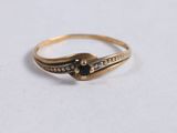 a close up of a gold ring with a black stone