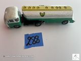 un camion vert et blanc et un autocollant bleu posé sur une table
