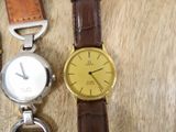 two watches sitting next to each other on a wooden table
