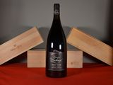 a bottle of wine sitting on a table next to two wooden boxes