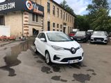 a small white car parked in front of a building