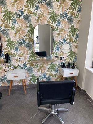 a room with a chair, mirror, and a mirror on the wall