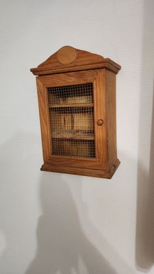 une petite armoire en bois contenant un oiseau