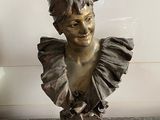a bronze bust of a woman with a ruffled collar
