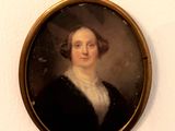 portrait of a woman in a black dress in a gold frame